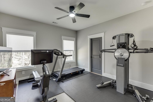 workout area with visible vents, a ceiling fan, and baseboards