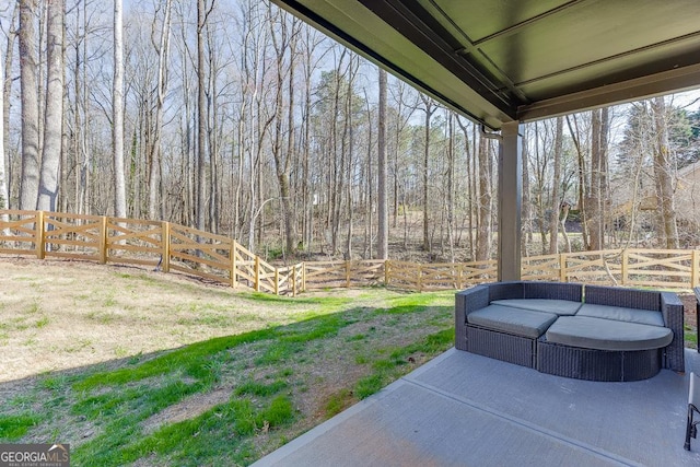 view of yard featuring a forest view, a fenced backyard, outdoor lounge area, and a patio area