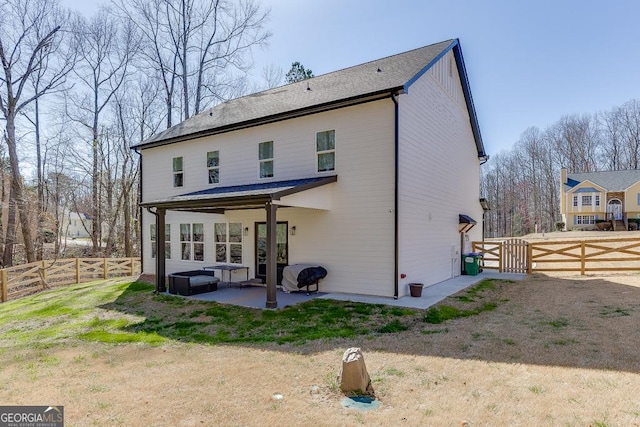 rear view of property with a gate, a patio area, and a fenced backyard