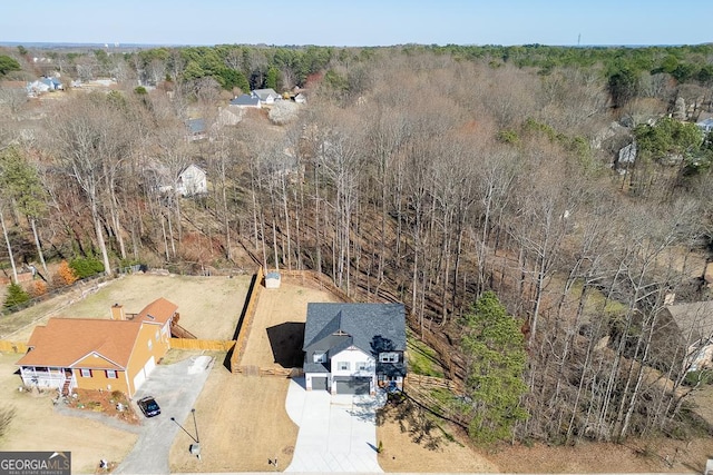 birds eye view of property featuring a wooded view