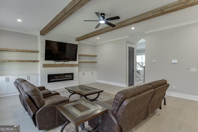 living area with beamed ceiling, light wood-style floors, a fireplace, baseboards, and stairs