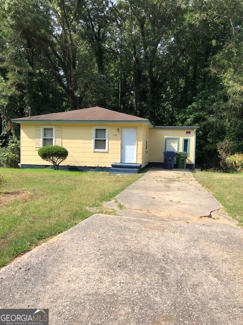 ranch-style house with driveway and a front lawn