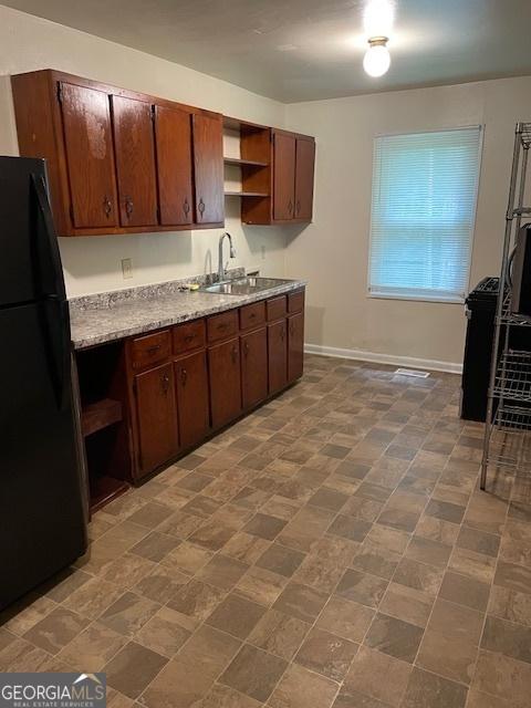 3720 Asbury Ln SW, Atlanta, GA 30331 - kitchen featuring freestanding refrigerator, a sink, open shelves, baseboards, and light stone countertops