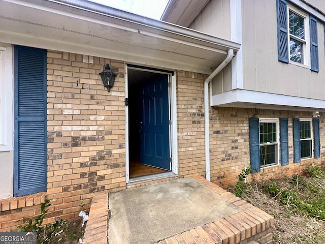 entrance to property featuring brick siding