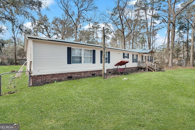 view of home's exterior with crawl space, metal roof, and a yard