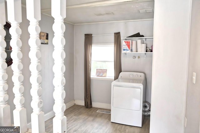 clothes washing area with baseboards, visible vents, washer / clothes dryer, wood finished floors, and crown molding