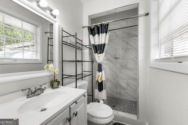 full bathroom with toilet, a stall shower, and vanity