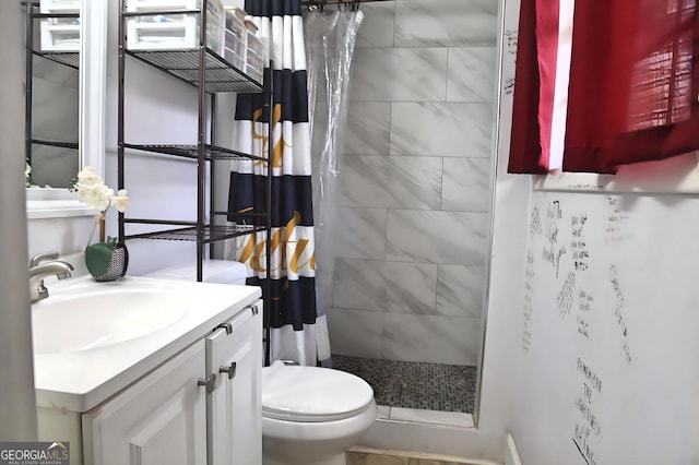 bathroom featuring toilet, a shower stall, and vanity