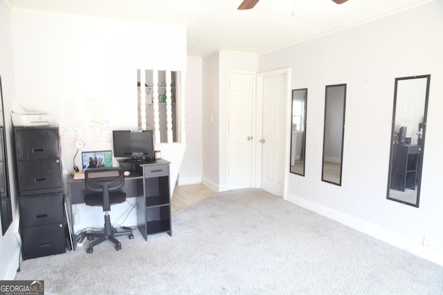 office space with carpet floors, crown molding, baseboards, and a ceiling fan