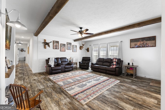 living room with beam ceiling, ceiling fan, a textured ceiling, and wood finished floors