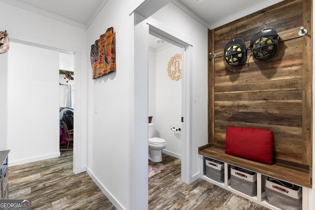 interior space featuring baseboards, wood finished floors, and crown molding