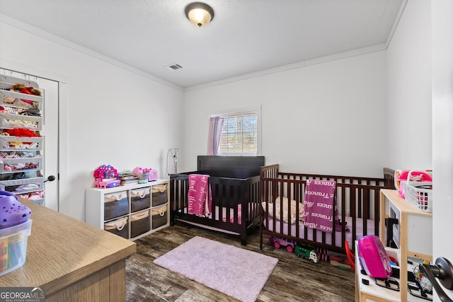 bedroom featuring ornamental molding, dark wood-style flooring, and visible vents