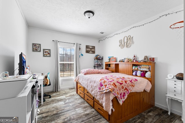 bedroom with visible vents, a textured ceiling, baseboards, and wood finished floors