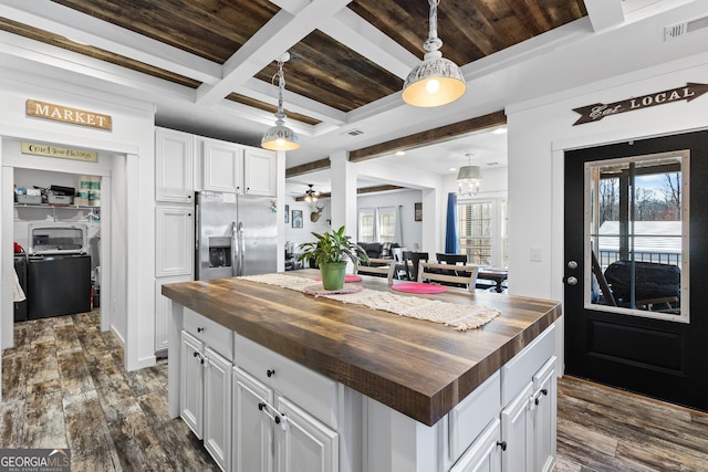 kitchen featuring visible vents, dark wood-style floors, butcher block counters, washing machine and dryer, and stainless steel refrigerator with ice dispenser