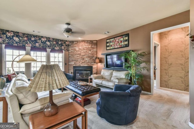 living area featuring a ceiling fan, carpet flooring, a fireplace, and visible vents