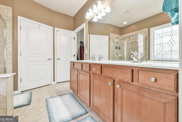 bathroom featuring double vanity, a stall shower, visible vents, tile patterned flooring, and a closet