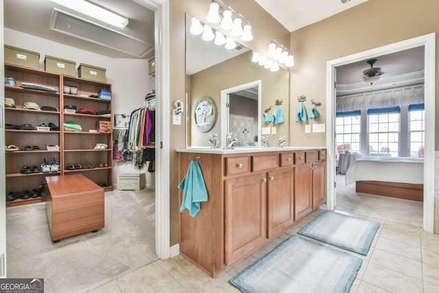 full bathroom with tile patterned flooring, a sink, a spacious closet, double vanity, and ensuite bath