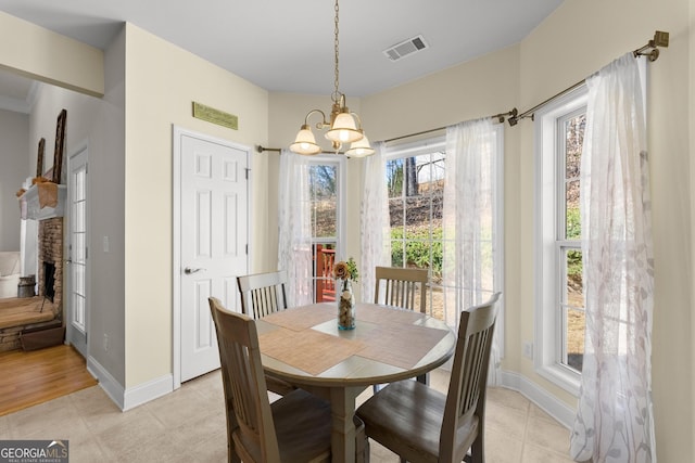 dining space with a chandelier, visible vents, baseboards, and light tile patterned floors