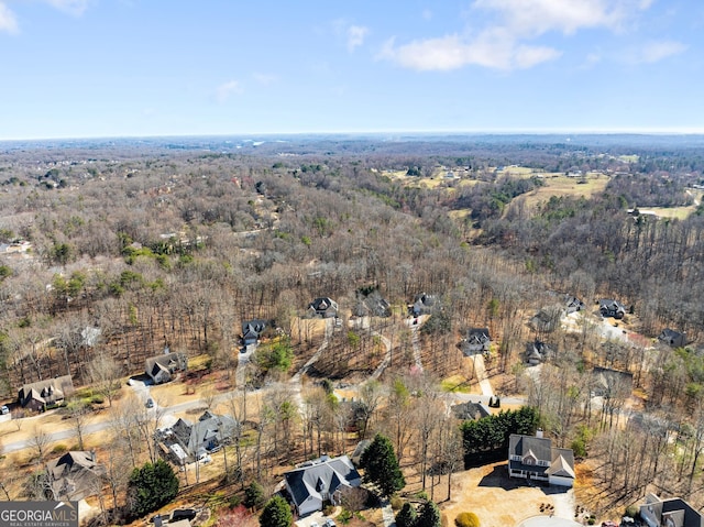 bird's eye view with a wooded view