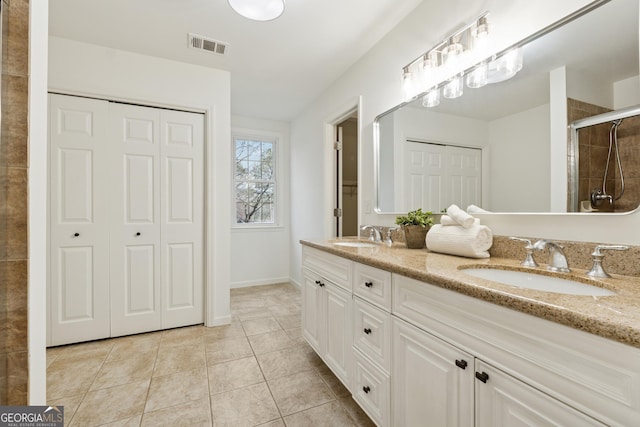 bathroom with visible vents, a sink, a tile shower, a closet, and tile patterned flooring