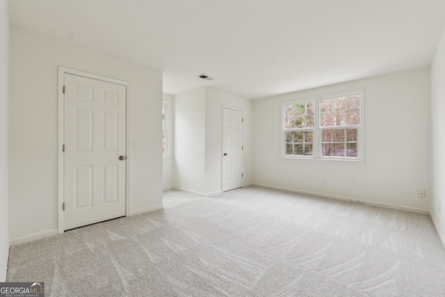 unfurnished bedroom featuring visible vents, carpet floors, and baseboards