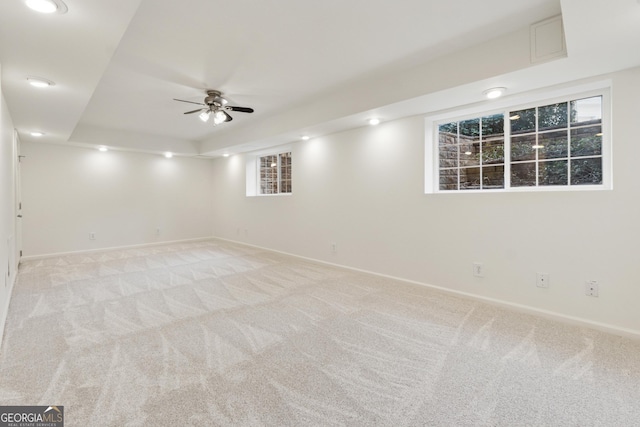 basement with recessed lighting, light colored carpet, a ceiling fan, and baseboards