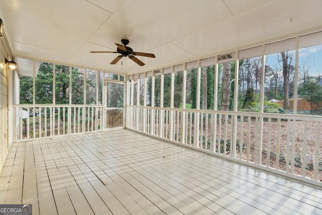 unfurnished sunroom with a ceiling fan