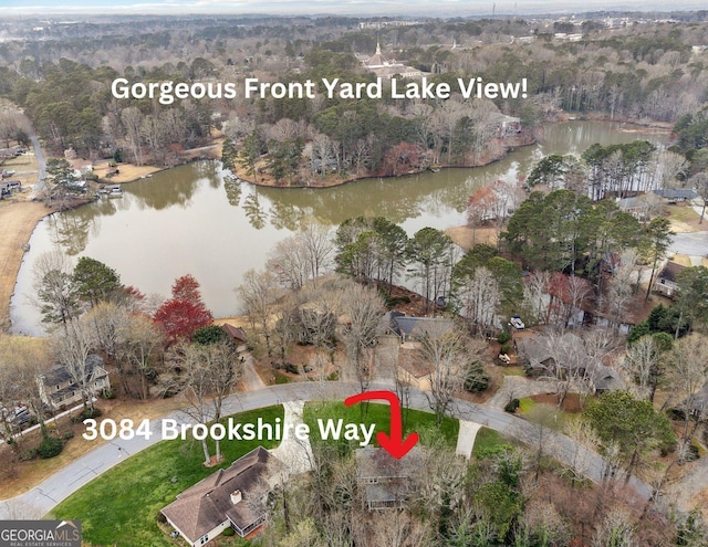 drone / aerial view featuring a forest view and a water view