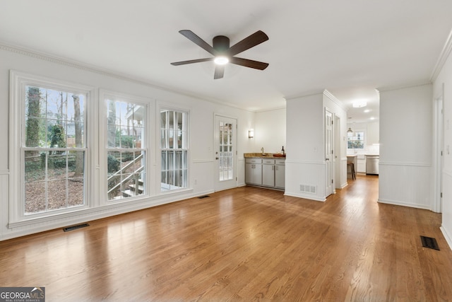 unfurnished living room featuring light wood-type flooring, visible vents, and ceiling fan