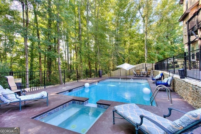 view of pool featuring a patio area, a pool with connected hot tub, and fence