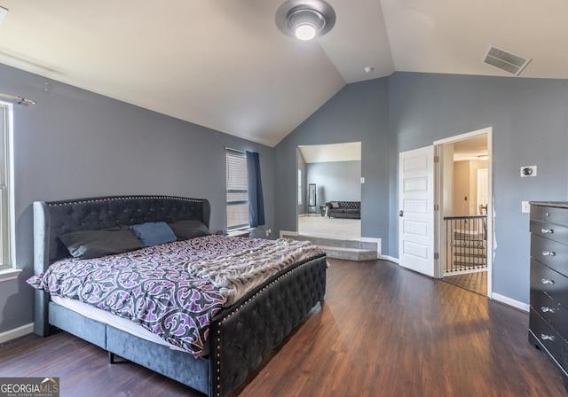 bedroom featuring baseboards, visible vents, vaulted ceiling, and wood finished floors