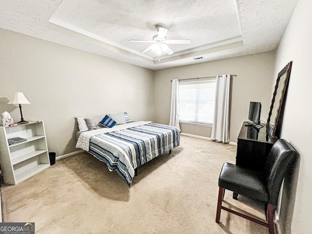 bedroom with visible vents, a raised ceiling, light colored carpet, and a textured ceiling