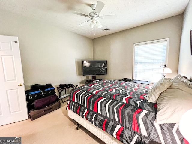 bedroom featuring visible vents, a textured ceiling, ceiling fan, and carpet floors