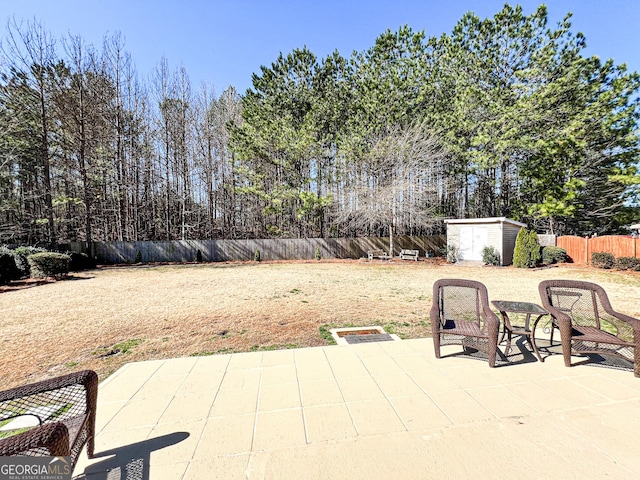 view of patio with a storage shed, an outbuilding, and a fenced backyard