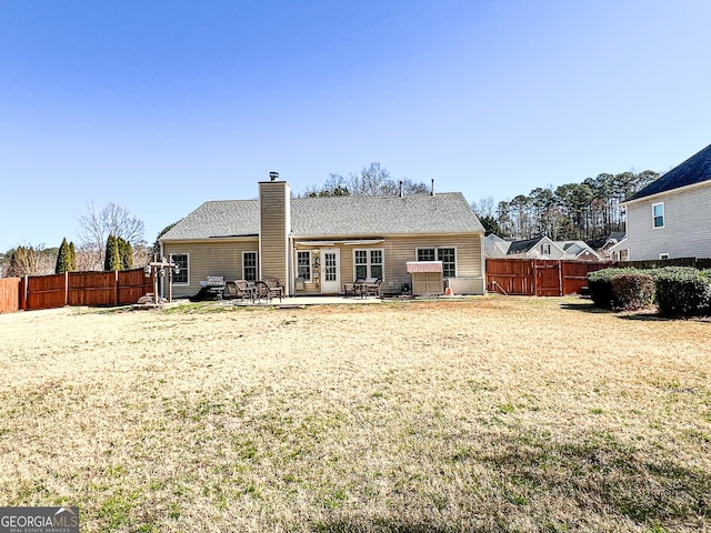 back of property featuring a lawn, a chimney, a patio, and fence