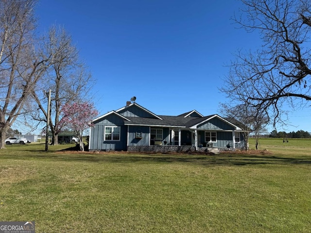 view of front of property with covered porch, a front lawn, and board and batten siding