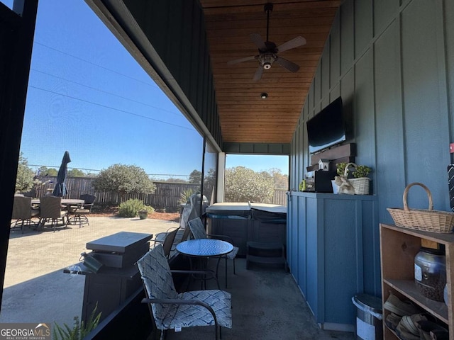 view of patio featuring a ceiling fan, outdoor dining area, a fenced backyard, and a hot tub