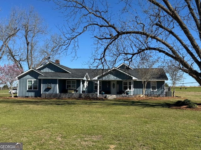 view of front of property featuring a chimney, board and batten siding, and a front yard