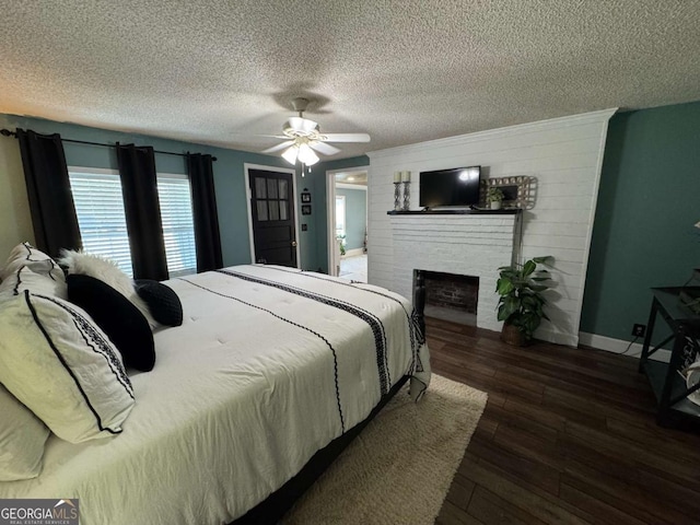 bedroom featuring a fireplace, wood-type flooring, ceiling fan, a textured ceiling, and baseboards