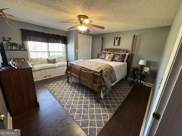 bedroom featuring ceiling fan, a textured ceiling, wood finished floors, and visible vents