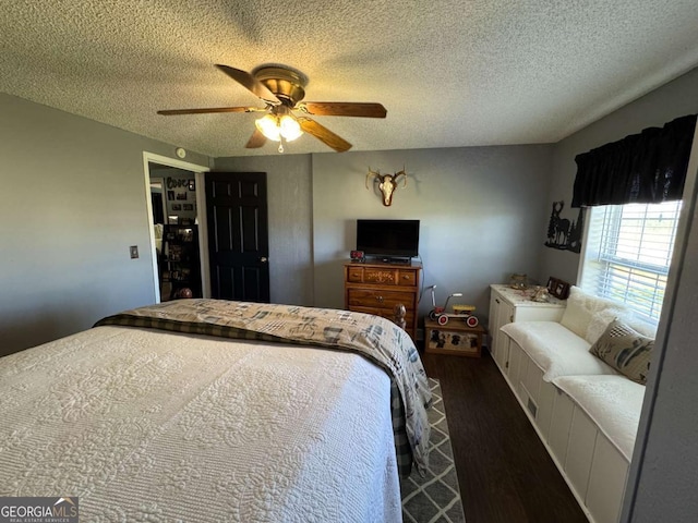 bedroom with dark wood finished floors, a textured ceiling, and ceiling fan