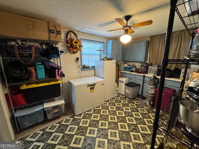 interior space featuring light countertops, fridge, freestanding refrigerator, a textured ceiling, and tile patterned floors