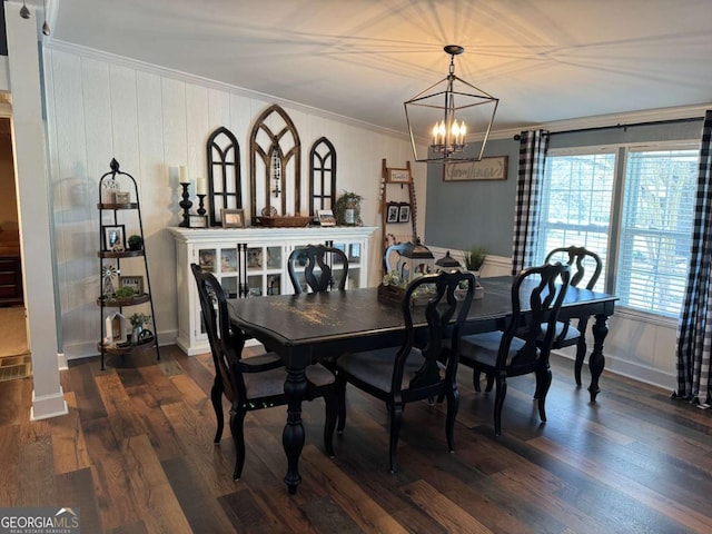 dining space featuring dark wood-style floors, ornamental molding, and an inviting chandelier