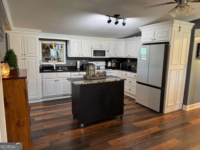 kitchen featuring white appliances, white cabinetry, dark wood-type flooring, and a sink