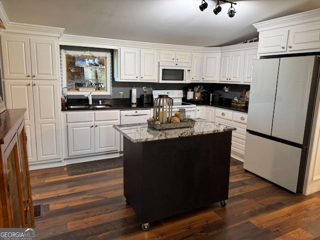 kitchen featuring a center island, dark wood-type flooring, white cabinetry, a sink, and white appliances