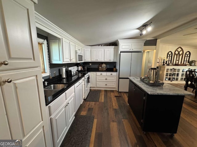 kitchen with white appliances, white cabinets, and a center island