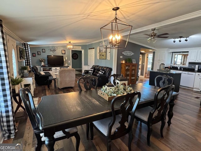 dining room with crown molding, dark wood-style flooring, and ceiling fan with notable chandelier