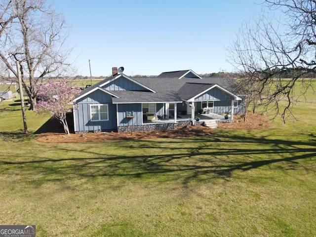 view of front of property featuring roof with shingles, board and batten siding, and a front yard