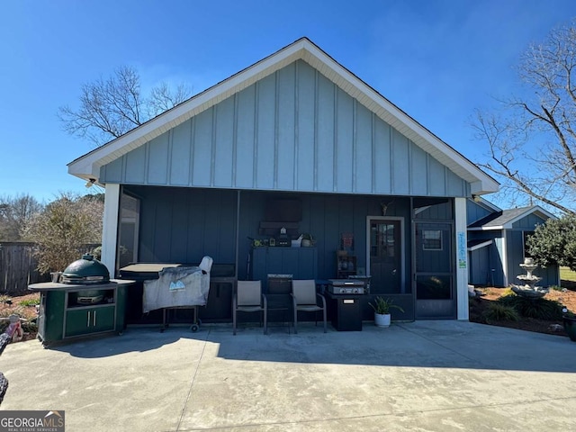 exterior space with board and batten siding and a patio area