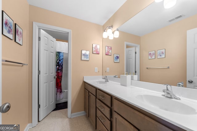 full bath featuring double vanity, a sink, visible vents, and baseboards